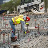 A working cutting a steel rebar cage.