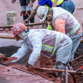 Workers spreading shotcrete on the framing.