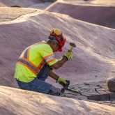 A worker hammering concrete.