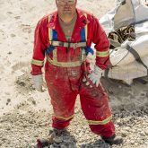 Overhead shot of person in red construction uniform on construction site.