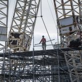 A worker standing on some scaffolding.