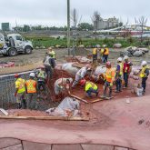 Workers spreading shotcrete on the framing.