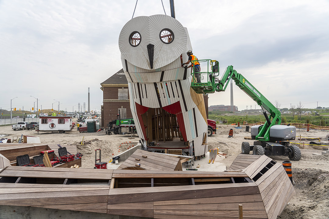 A giant snowy owl structure in a construction zone.