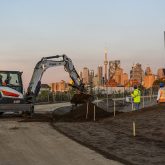 An excavator next to a pile of soil.