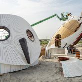 The face of a snowy owl structure sitting next to its body on a construction site.