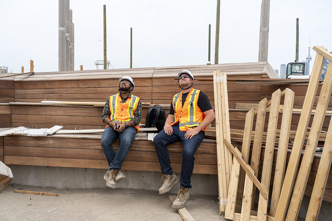 Workers sitting on the benches in front of the owl.