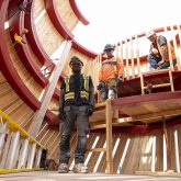 Three workers standing inside the owls body.